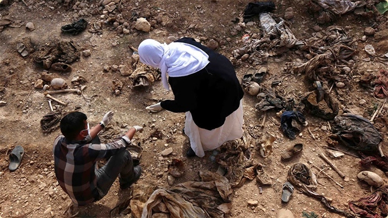 وێنەیەکی ئەرشیڤی گەڕانی ژنێکی ئێزدی لەنێو گۆڕێکی بەکۆمەڵ بەدوای ئێسکوپرووسکی کەسوکاری 